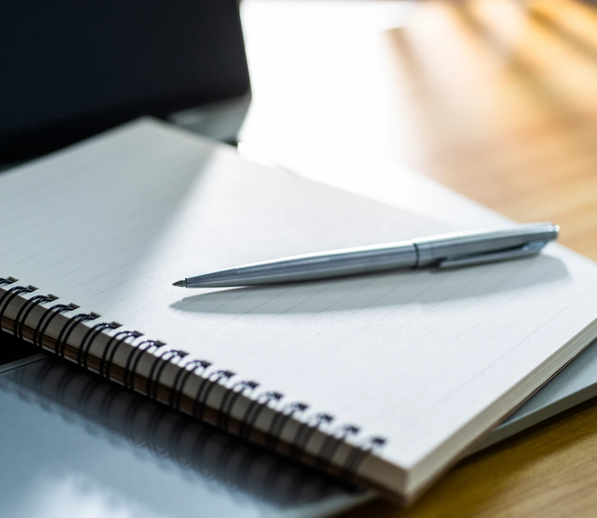 Open spiral notebook with pen